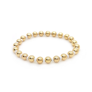 Detail of 18K gold and white beads elastic bracelet with minimalist beaded design