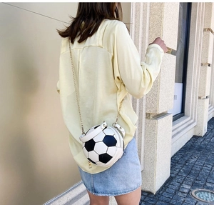 Soccer ball shaped crossbody bag with black and white pattern and gold chain strap