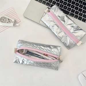 Macro detail of silver quilted pencil case with pink zipper showing large storage capacity