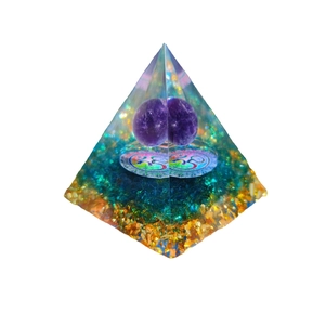 Orgone energy pyramid with purple crystal sphere and Om symbol on white background