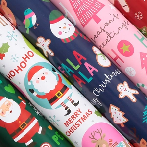 Variety of colorful Christmas gift wrapping paper rolls with Santa and reindeer motifs