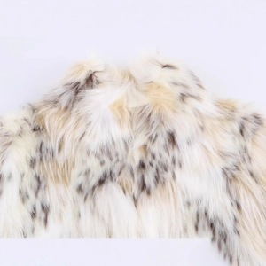 Chic women's faux fur coat in cream with brown spots, showcasing soft fluffy texture