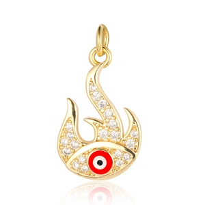 Detailed macro shot of a gold flame pendant with a red devil eye and sparkling zircon stones