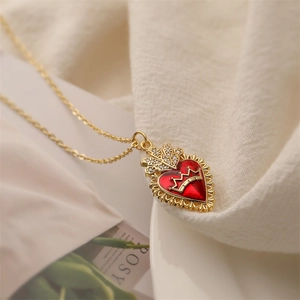 Dettaglio del ciondolo a cuore con corona dorata in smalto rosso e zirconi brillanti