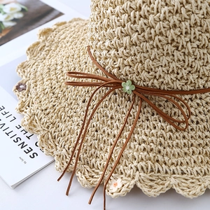 Summer straw beach hat with hollow weave and scalloped brim with floral accents