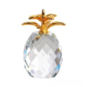 Macro shot of faceted crystal pineapple ornament with detailed gold metal leaf top