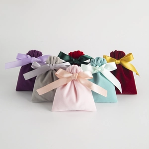 Nahaufnahme von bunten Samt-Schmuckaufbewahrungstaschen mit eleganten Satinband-Schleifen.
