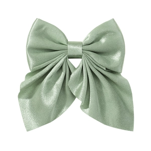 Detailed view of a high-gloss green satin fabric bow hair clip on a clean white background