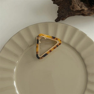 Close-up of leopard print acetate hair claw with hollow triangle design and gold spring