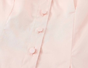 Detail of pink fabric texture and matching buttons on this stylish ruffle sleeve blouse