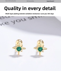 Macro shot of gold-plated S925 sterling silver star stud with a green gemstone center