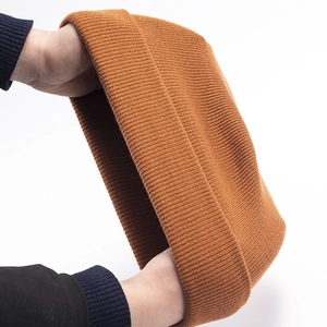 Close-up showing the high elasticity and stretch of the caramel knit beanie hat