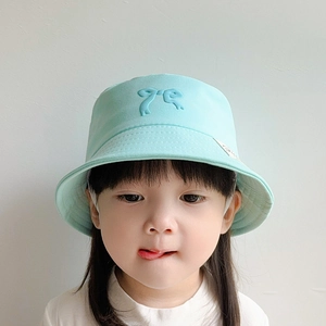 Detail showing the mint green cotton kid fisherman hat with a decorative bow and chin strap