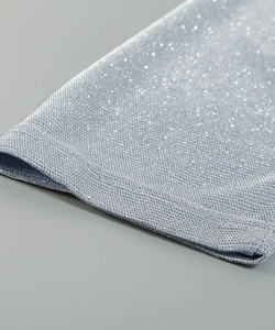 Close-up of sparkling silver metallic fabric showing intricate glitter weave and texture