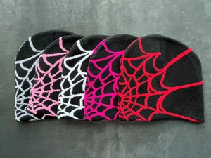 Detailed macro view of five knitted beanies with various spider web jacquard patterns