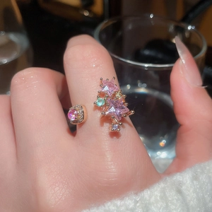 Detailed macro of a gold star ring with pink crystals and zircon stones on a model hand