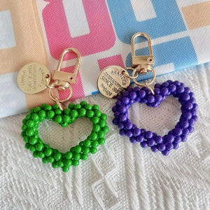 Handmade woven pearl heart keychains in green and purple with golden metal alloy hooks