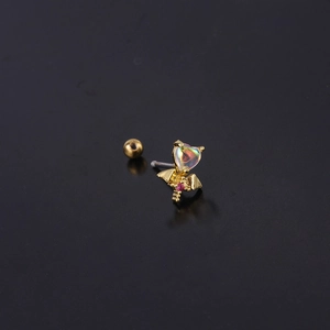 Macro shot of gold bat wing stud earring with heart opal and small red gem detail