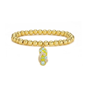 Detailed shot of 18K gold-plated beaded bracelet with green evil eye slipper charm