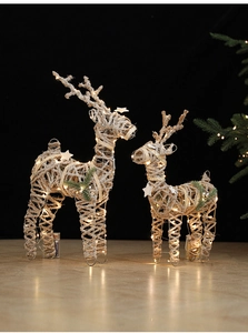Close-up of warm glowing LED reindeer figurines made of champagne hemp rope and iron