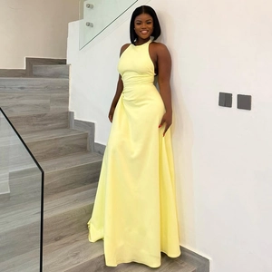 Detail of elegant yellow sleeveless maxi dress showing ruched waist and silky fabric