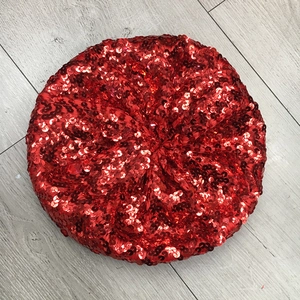 Detailed top-down view of shiny red sequins on a fashion beret hat for women
