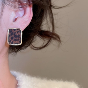 Détail de boucles d'oreilles carrées à motif léopard avec cadre en métal doré