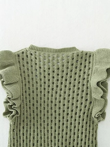Detail of green knit vest featuring crochet openwork patterns and ruffled cap sleeves