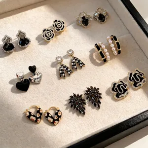 Elegante Kollektion schwarzer Blumen- und Schleifenohrringe mit Zirkon- und Perlenakzenten