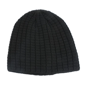 Detail of black ribbed knit beanie showing thick elastic weave texture on white background
