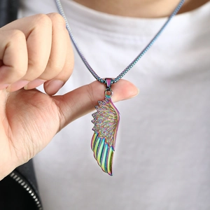 Macro shot of colorful iridescent feather wing pendant on a fine metal chain link