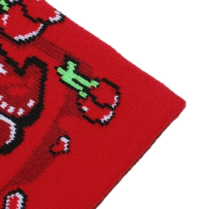 Detailed view of red knitted fabric with pixelated cherry and heart embroidery patterns