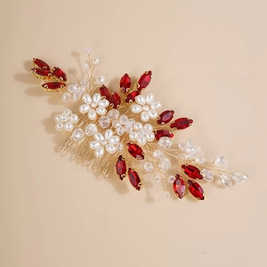 Detail of bridal hair comb with red rhinestones and white pearls on gold wire