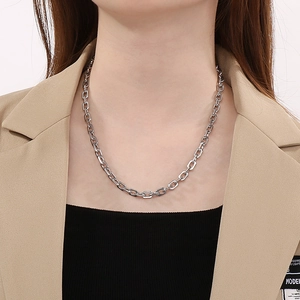 Close-up of silver stainless steel chain necklace worn with a khaki suit jacket