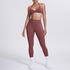 Dettaglio del set yoga rosso ruggine con reggiseno sportivo halter e leggings a vita alta