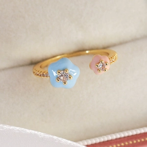 Close-up of pastel floral open ring with colorful enamel petals and cubic zirconia stones