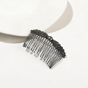 Detailed close-up of a black metal hair comb with sparkling crystals on white background