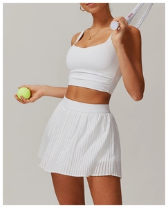 Close-up of white tennis set featuring pleated sports skirt and U-neck cropped top