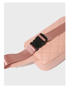 Detail of pink quilted waist bag featuring a durable black plastic buckle and woven strap