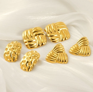 Detailed macro shot of 18k gold-plated geometric weave earrings on white silk