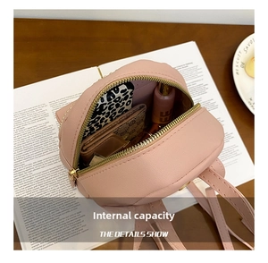 Internal capacity of pink punk rivet backpack showing cosmetics and leopard print items