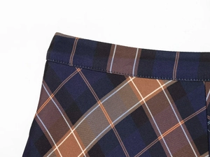 Detailed close-up showing the blue and brown plaid fabric texture and fine stitching on skirt