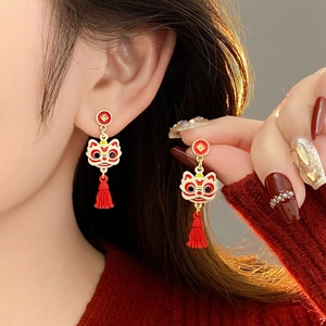 Détail de boucles d'oreilles lion dansant avec pompons rouges de style chinois vintage