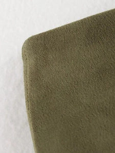 Detail shot of the olive green suede fabric texture on an elegant midi pencil skirt