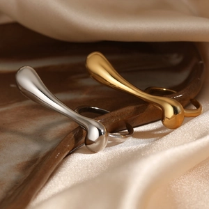 Minimalist irregular waterdrop open rings in polished gold and silver on silk backdrop