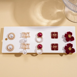 Gros plan d'un lot de 5 paires de boucles d'oreilles avec fleurs rouges et perles