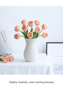 Macro view of 12 lifelike peach PU tulips in a white ribbed ceramic vase for home decor