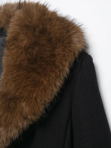 Detail of premium wool blend coat featuring a thick brown faux fur collar and black fabric