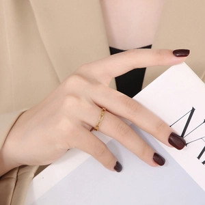 Detailed view of a gold chain-link hollow ring worn on a finger for a minimalist style