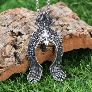 Vintage stainless steel flying eagle pendant necklace shown on natural tree bark
